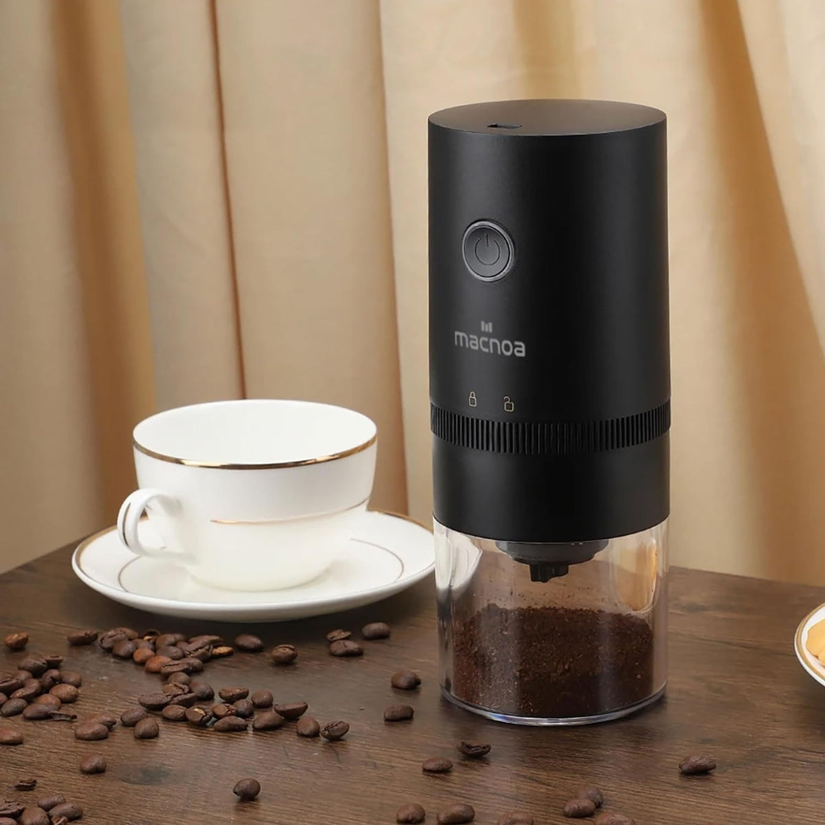 there is cuo of coffee, Macnoa Coffee Grinder and beans all around the table