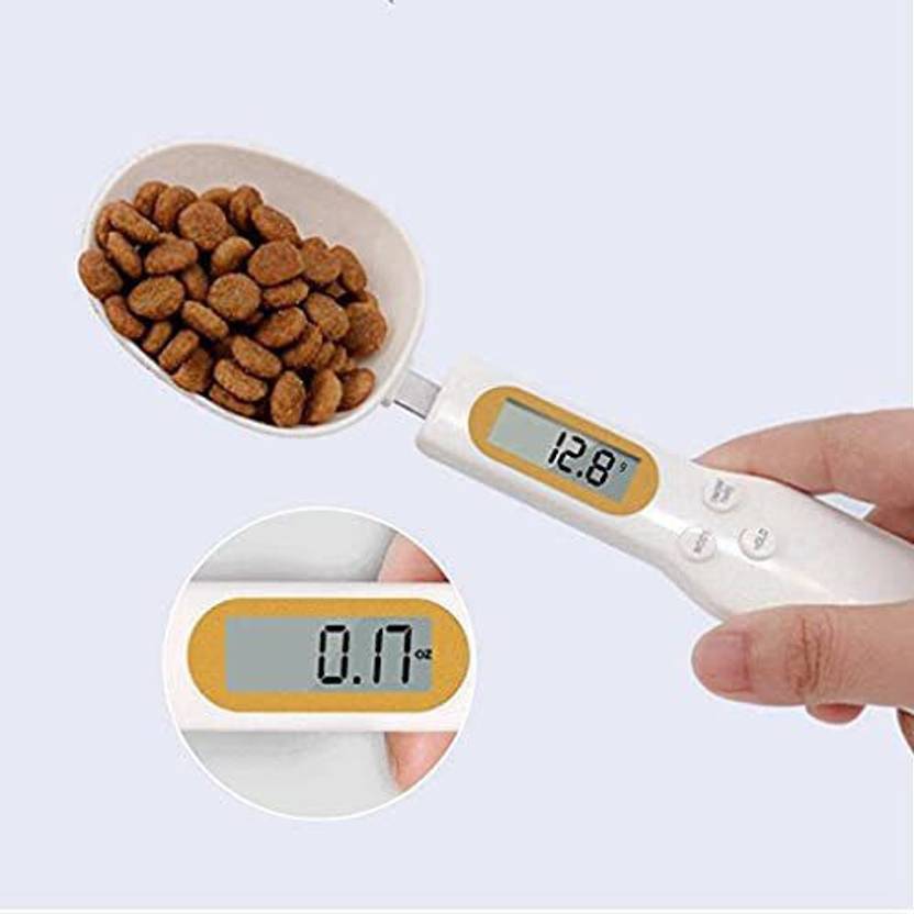 A Person is Holding some food objects on Digital Spoon Scale 500g Kitchen Measuring Spoon and it shows its weight.