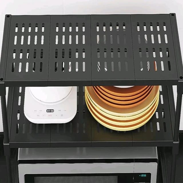 White double-layer rack organizing plates and a microwave on a countertop