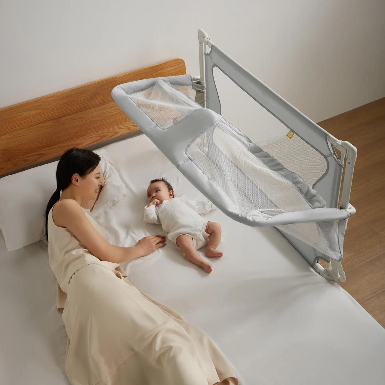 a mother having her time with her baby, who uses Height Adjustable Baby Bed to sleep