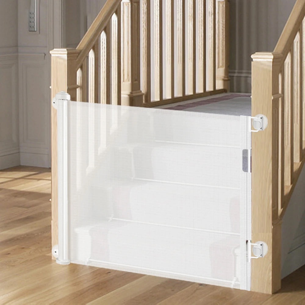 A retractable baby and pet safety gate positioned in front of a staircase