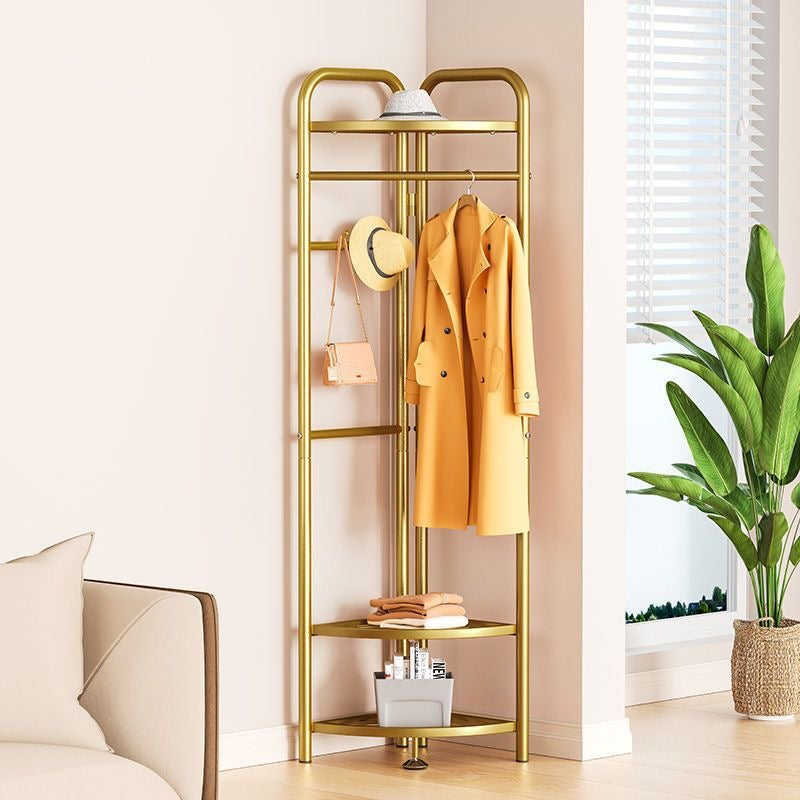 Golden color garment clothing rack where a coat, bag and a hat is hanged. A hat is kept above the hanging area. There are two storage under the hanging area where clothes has been kept and skincare essential kit below..