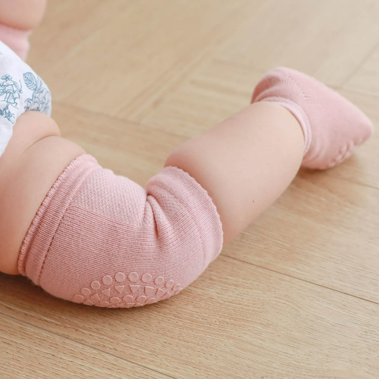 Baby crawling in Pink knee Pads.