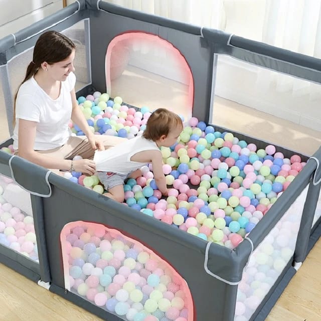 A Mother and Baby Plays Inside a Baby Playpen.