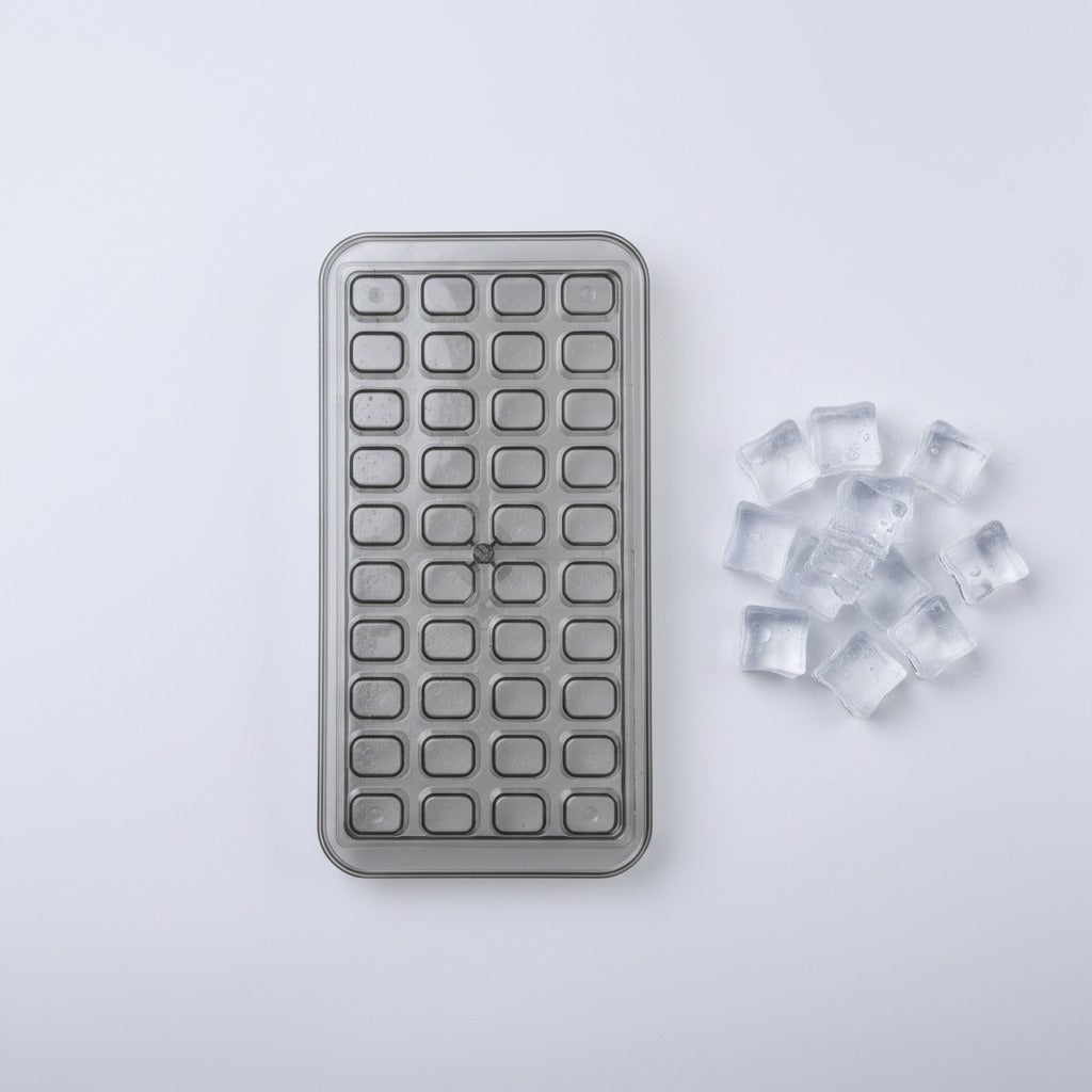 ice cube tray with ice cubes on a light gray background