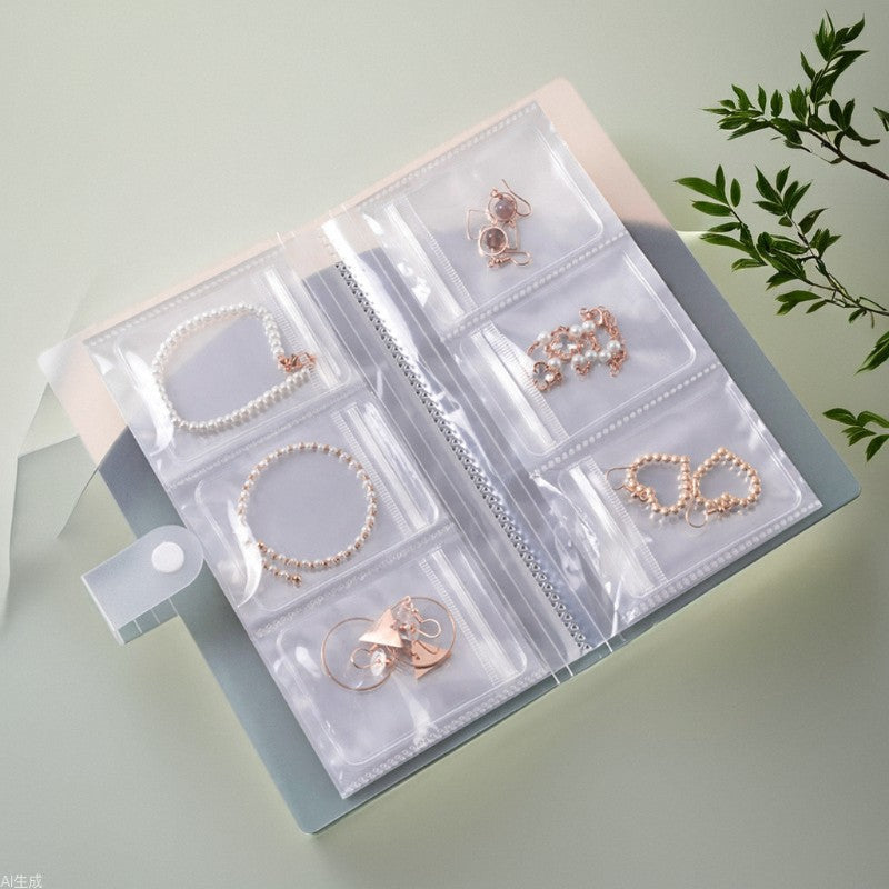 A transparent jewelry storage book with multiple clear pocket sleeves displaying neatly organized earrings, bracelets, and rings.