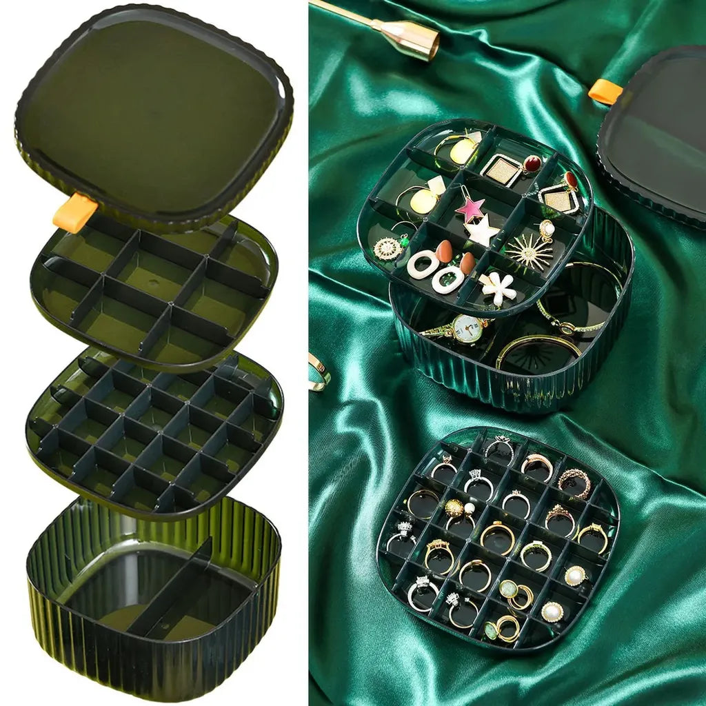 A green cosmetic and jewelry storage box with a lid, containing rings and earrings neatly organized inside.