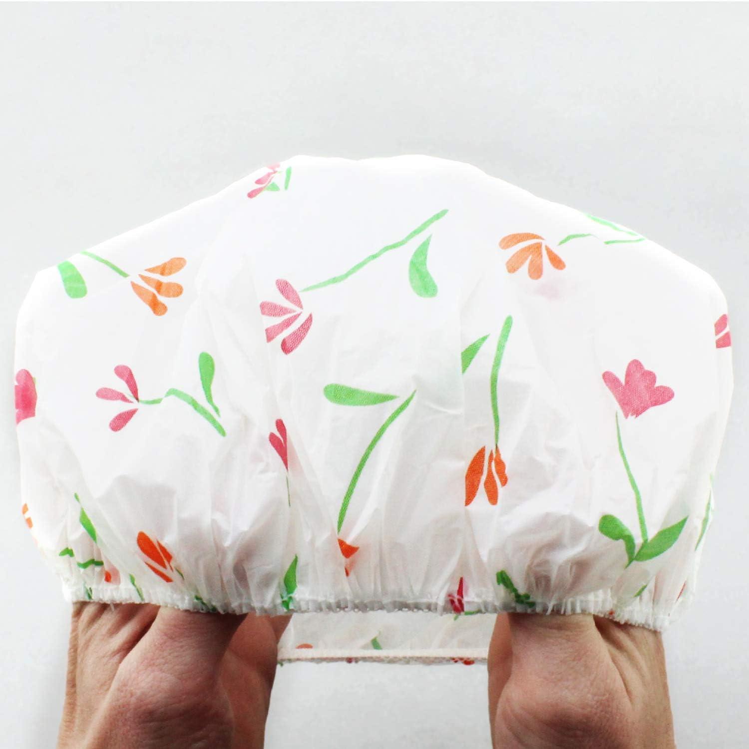 Floral-patterned shower cap held by a hand on a light gray background