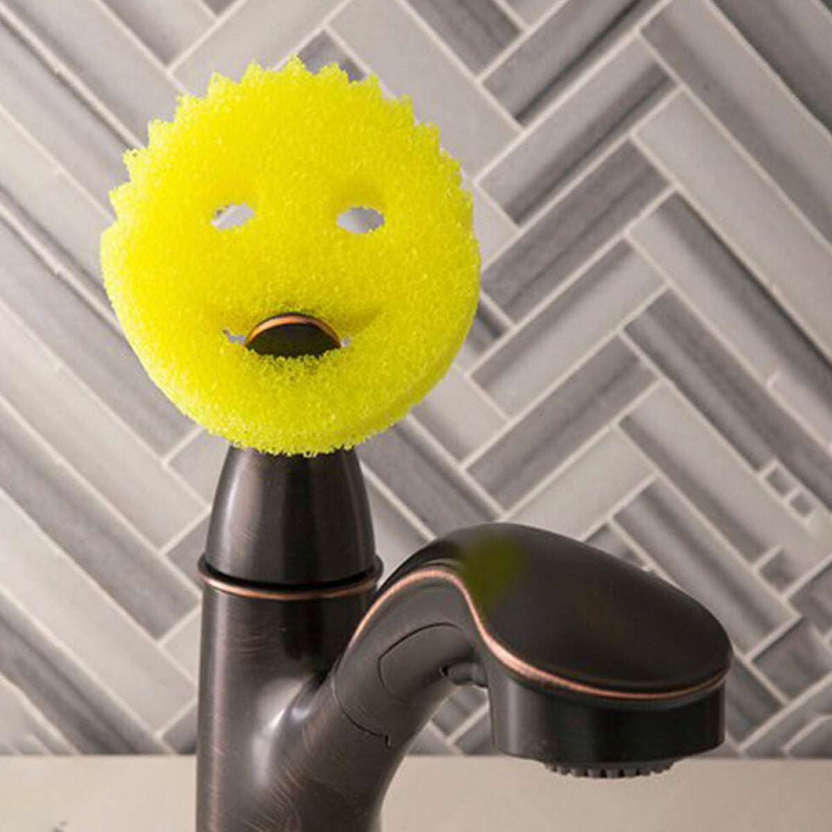 Smiley Face Kitchen Scrubber is Placed on a Water Pipe.