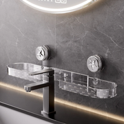 Clear suction bathroom shelf mounted on a tiled bathroom wall above a sink, beside a modern black faucet.