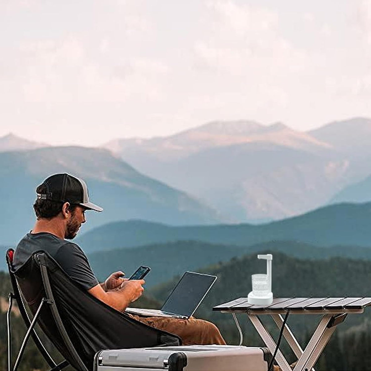 a man working on laptop while traveling with travel friendly water dispenser
