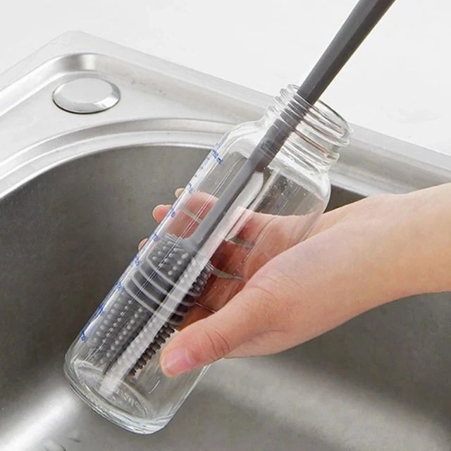 Someone cleaning a bottle with the help of a Silicone Corner Brush for bottles
