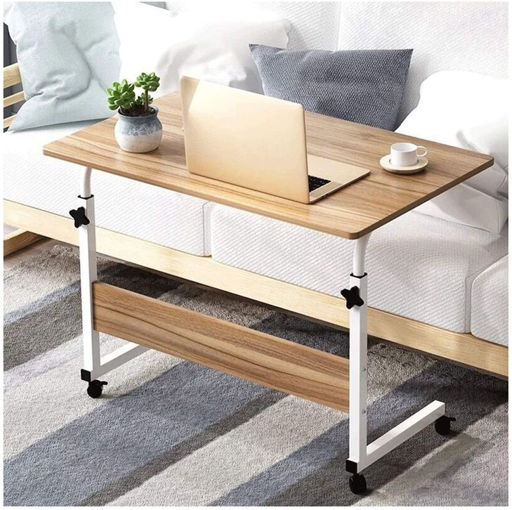 Wooden color Adjustable Movable Laptop Table placed beside to a sofa in a living room 