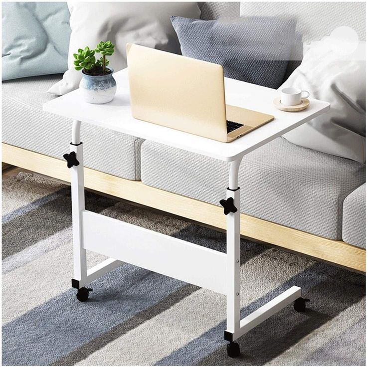 White color Adjustable Movable Laptop Table placed beside to a sofa in a living room