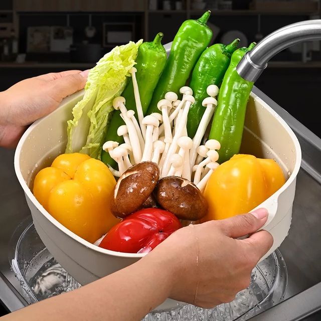 Someone is cleaning vegetables with the Double Layer Vegetable Fruit Washing Drain Basket Storage
