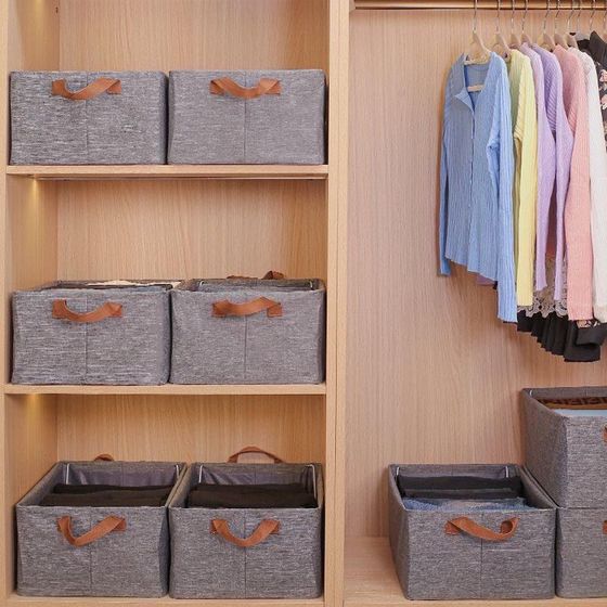 A neatly organized cloth wardrobe storage organizer with multiple baskets and a variety of clothes neatly arranged inside