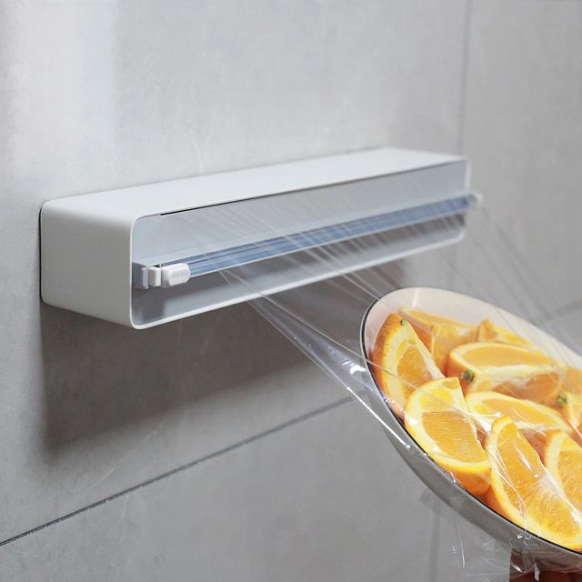 The Wall Mount Instant Plastic Wrap Dispenser with Slide Cutter is placed on the wall
