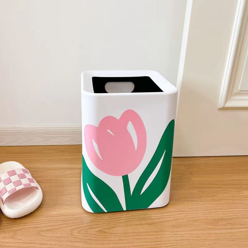 Square shaped Flower Design Home Trash Bin placed next to a slipper in a room  
