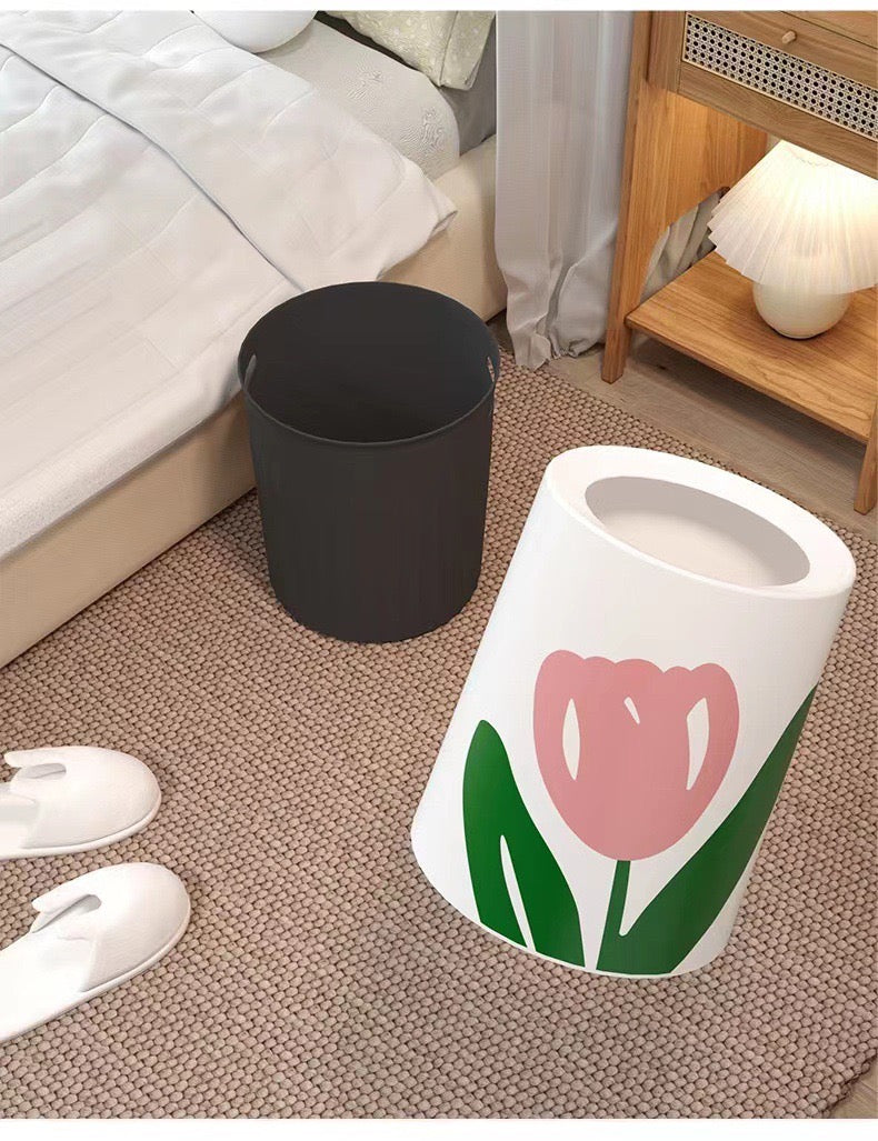 Home Trash Bin placed next to a bed with Flower design cover removed and kept aside in a room 
