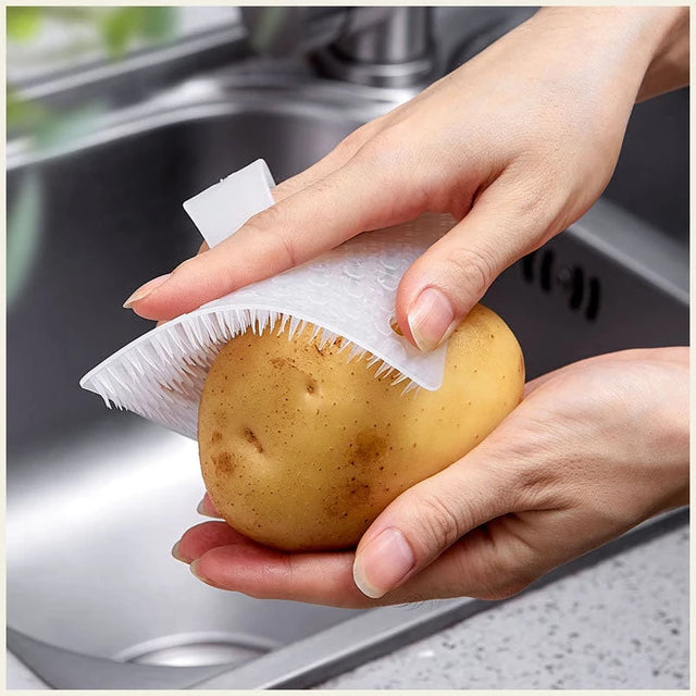 Someone rubbing a potato with the help of a Multifunctional Fruit Vegetable Rubbing Brush