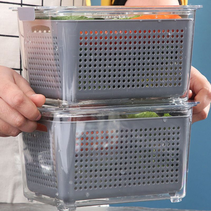 A person holds two plastic containers filled with vegetables, using the Fridge Storage Basket Refrigerator for storage